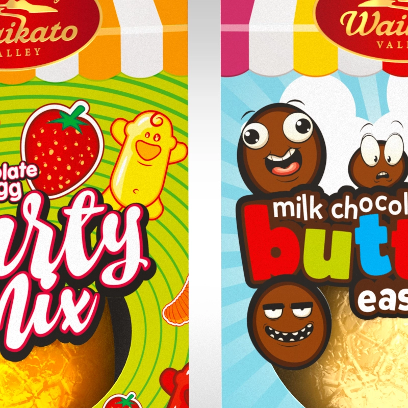 Closeup of two Waikato Valley Easter eggs, one with a "Party Mix" label and a cartoon strawberry, and the other with a "Buttons" label and cartoon faces.