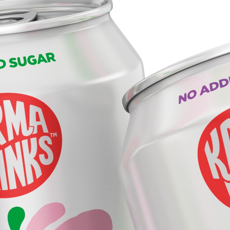 Closeup of Two white cans of Karma Drinks with "No Sugar" and "No Added Sugar" labels