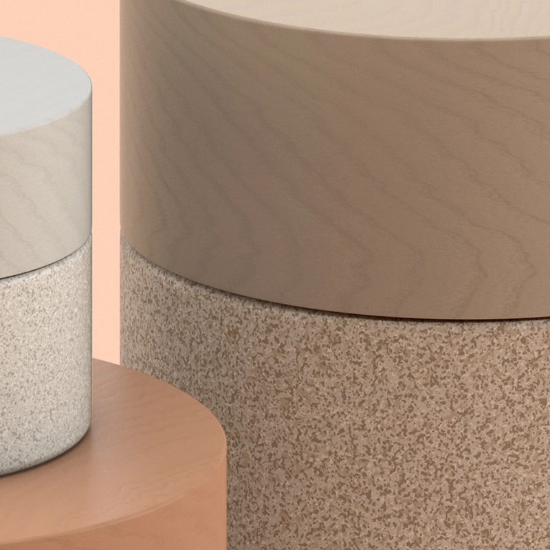 Closeup of three cylindrical containers with different textures: smooth wood, speckled brown, and a rough, sandy texture.