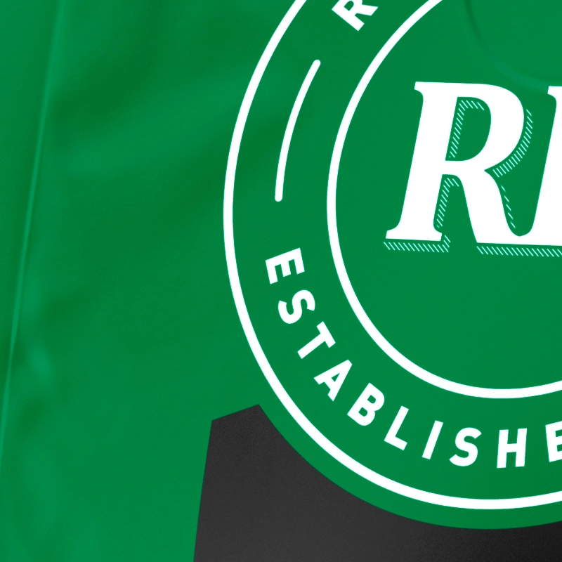 A close-up of a green and white logo with the letter "R" and the word "ESTABLISHED".