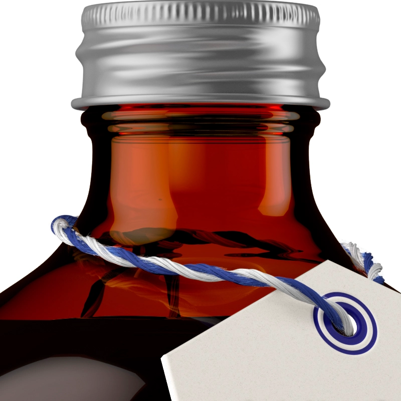 A close-up of a brown glass bottle with a silver lid and a blue and white tag tied around the neck.