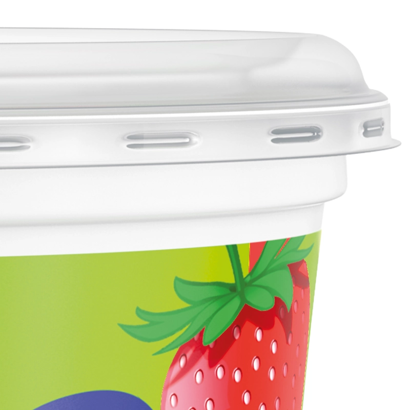 A close-up of a yoghurt pot with a red strawberry on the side and a clear plastic lid.