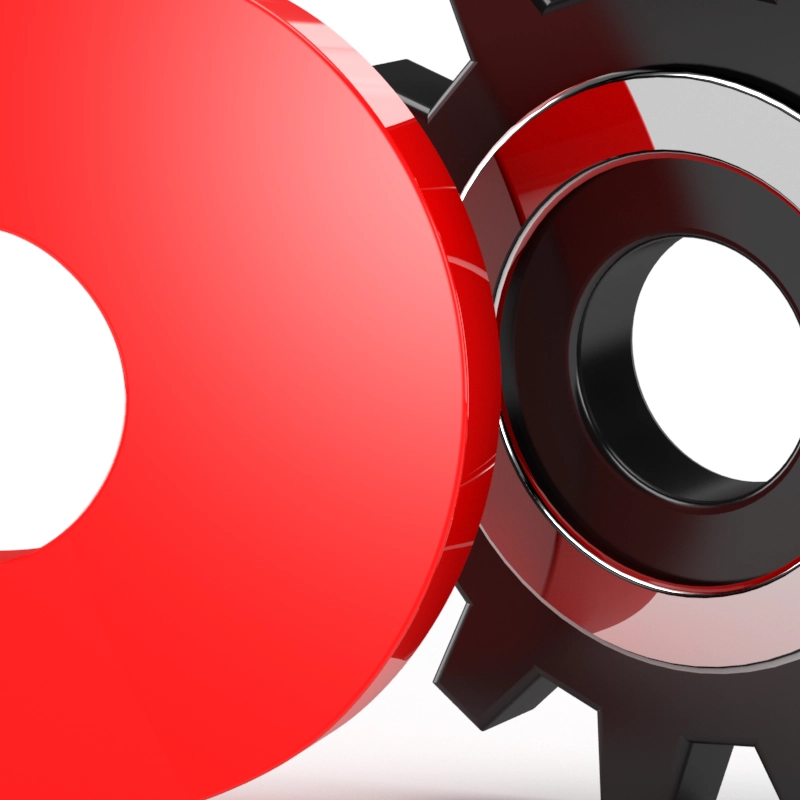 A red magnet and a black gear interlocked together.